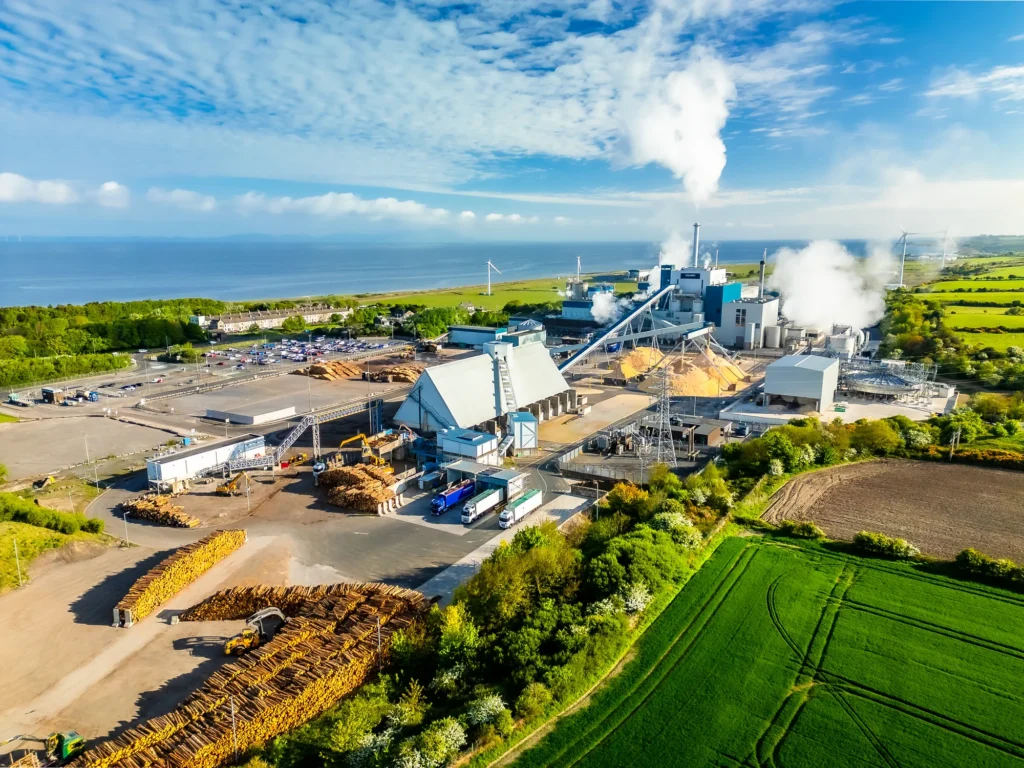 Aerial view of the Holmen Board and Paper mill at Workington with log stacks and the Solway coast behind