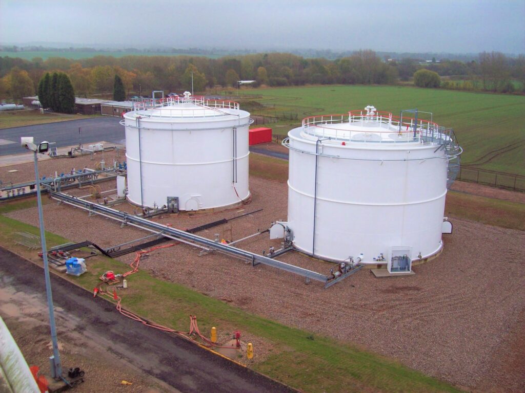Aerial view of two white ambient storage tanks and pipework
