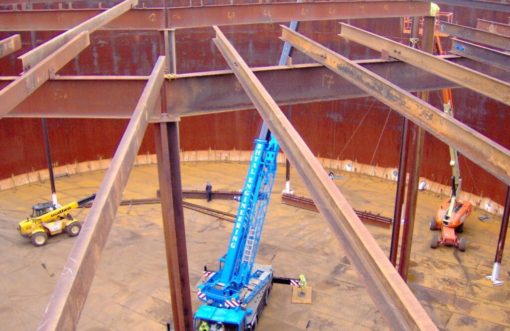 Steel beams and a crane inside a field-erected storage tank during construction
