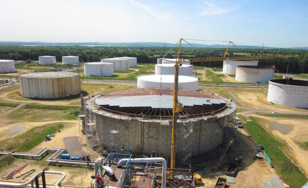 Scaffolding and roof plates inside a large storage tank under construction